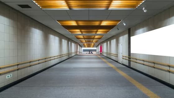 Underground pedestrian walkway with warm wood-slat ceiling lighting